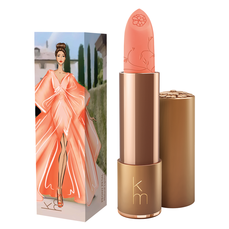 peach pink lipstick in gold cannister next to a box with a lady in a peach dress 