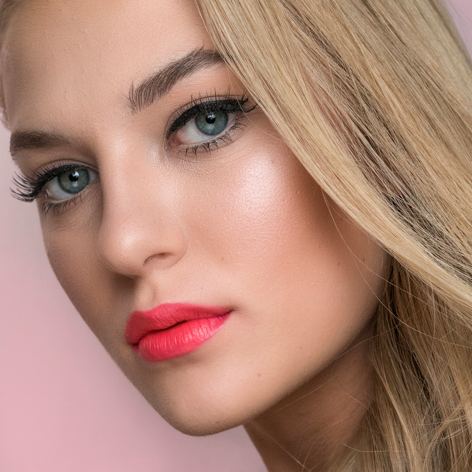 Poppy coloured lipstick on a model with blonde hair 