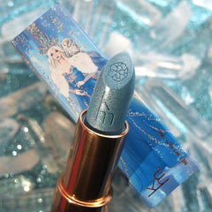 Blue lipstick with gold cap on a blue lipstick case featuring an illustration of a woman with a crown.