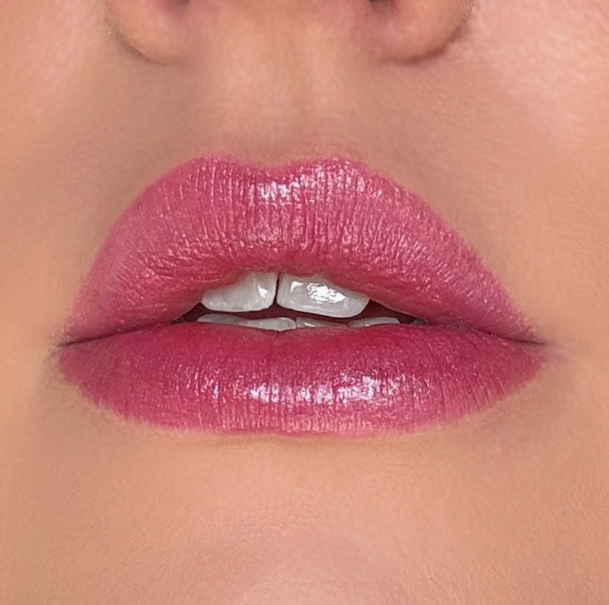 Close-up of a person wearing pink lipstick on a neutral background